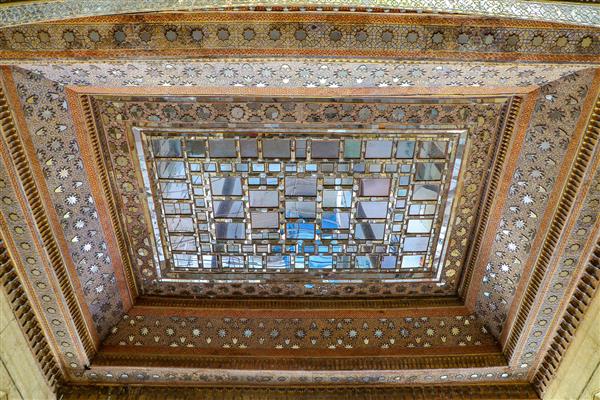 تصویر سقف چوبی تالار اصلی با تزئینات آینه‌کاری مربعی و نقوش کنده‌کاری شده