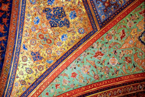 عکس نمای نزدیک از سقف و طاق مقرنس‌کاری شده با نقوش طلایی و رنگی کاخ عالی قاپو یا چهلستون