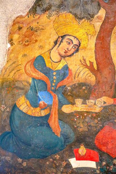 عکس نمای نزدیک از نقاشی دلبر صفوی در حال تعارف نوشیدنی بر سینی در چهلستون