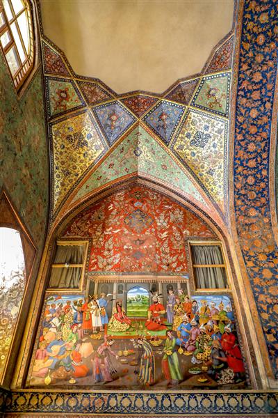 قاب کامل نقاشی بزم شاه عباس دوم زیر طاق گنبدی و مقرنس‌کاری سقف