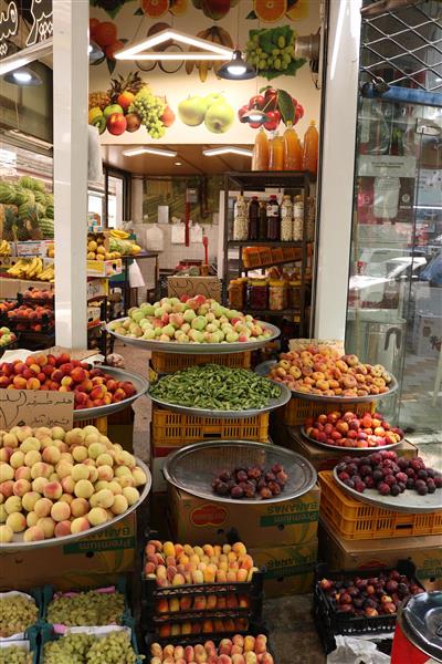 بساط میوه‌فروشی در بازار سنتی ایران با انبوه میوه‌های تابستانی مانند هلو و آلو