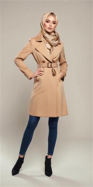 عکس مدل زن با پالتوی بژ و کمربند سگک‌دار برای تبلیغات رسمی
