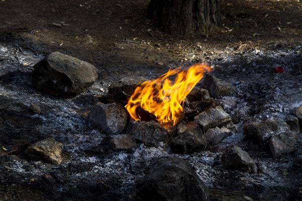 شعله آتش در میان سنگهای سیاه