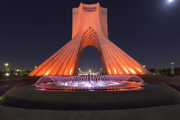 نمای شب برج آزادی تهران با نورپردازی نارنجی و آب‌نما جهت چاپ پوستر دیواری پذیرایی و دفاتر اداری