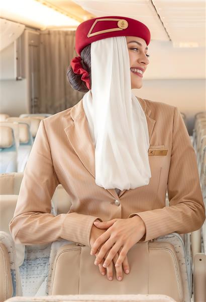 تصویر مهماندار هواپیمایی امارات در کابین مسافران مناسب برای پوستر دیواری آژانس‌های هواپیمایی و دکوراسیون دفاتر خدمات مسافرتی و تابلو شاسی لوکس