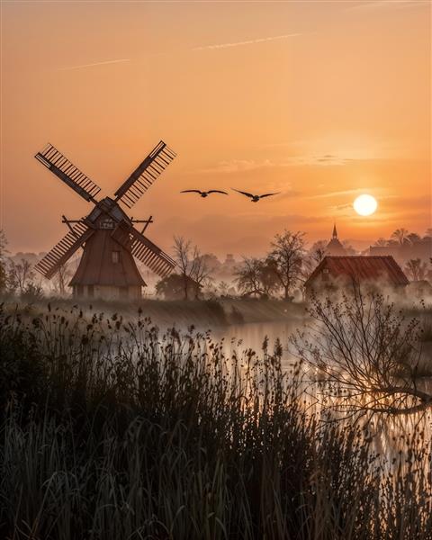 پوستر دیواری منظره رویایی آسیاب بادی کنار برکه و پرواز پرندگان در سپیده دم مناسب ویلا، هتل و اتاق نشیمن جهت چاپ دیوارپوش سه بعدی و تابلو فرش