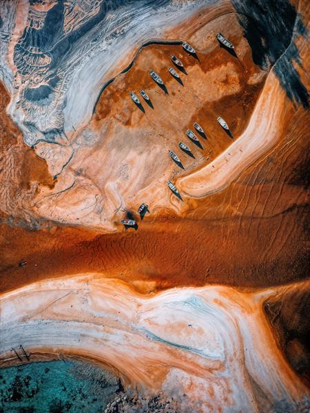 عکس هوایی از قایق‌های رها شده در ساحل کویری با تنالیته نارنجی و فیروزه‌ای ویژه تابلوهای دکوراتیو و دفاتر معماری