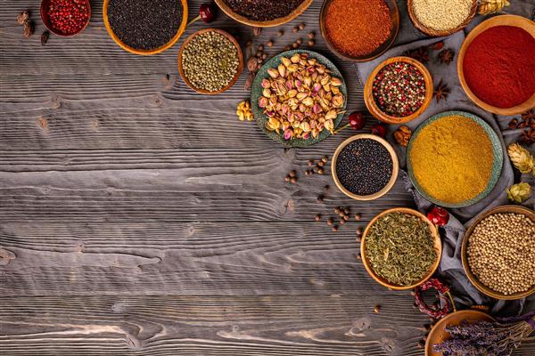 کادر بندی ادویه جات متنوع روی پس زمینه چوب تیره مناسب برای چاپ بنر، پوستر دیواری رستوران و رومیزی های چاپی