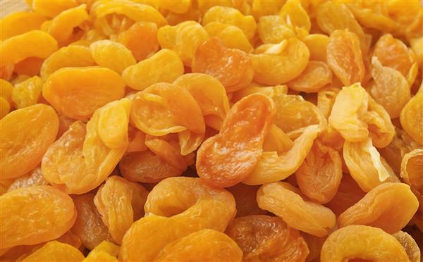 نمای نزدیک از برگه زردآلو و میوه خشک شده با رنگ نارنجی زنده مناسب برای بسته‌بندی مواد غذایی، پوستر دیواری آشپزخانه و عطاری