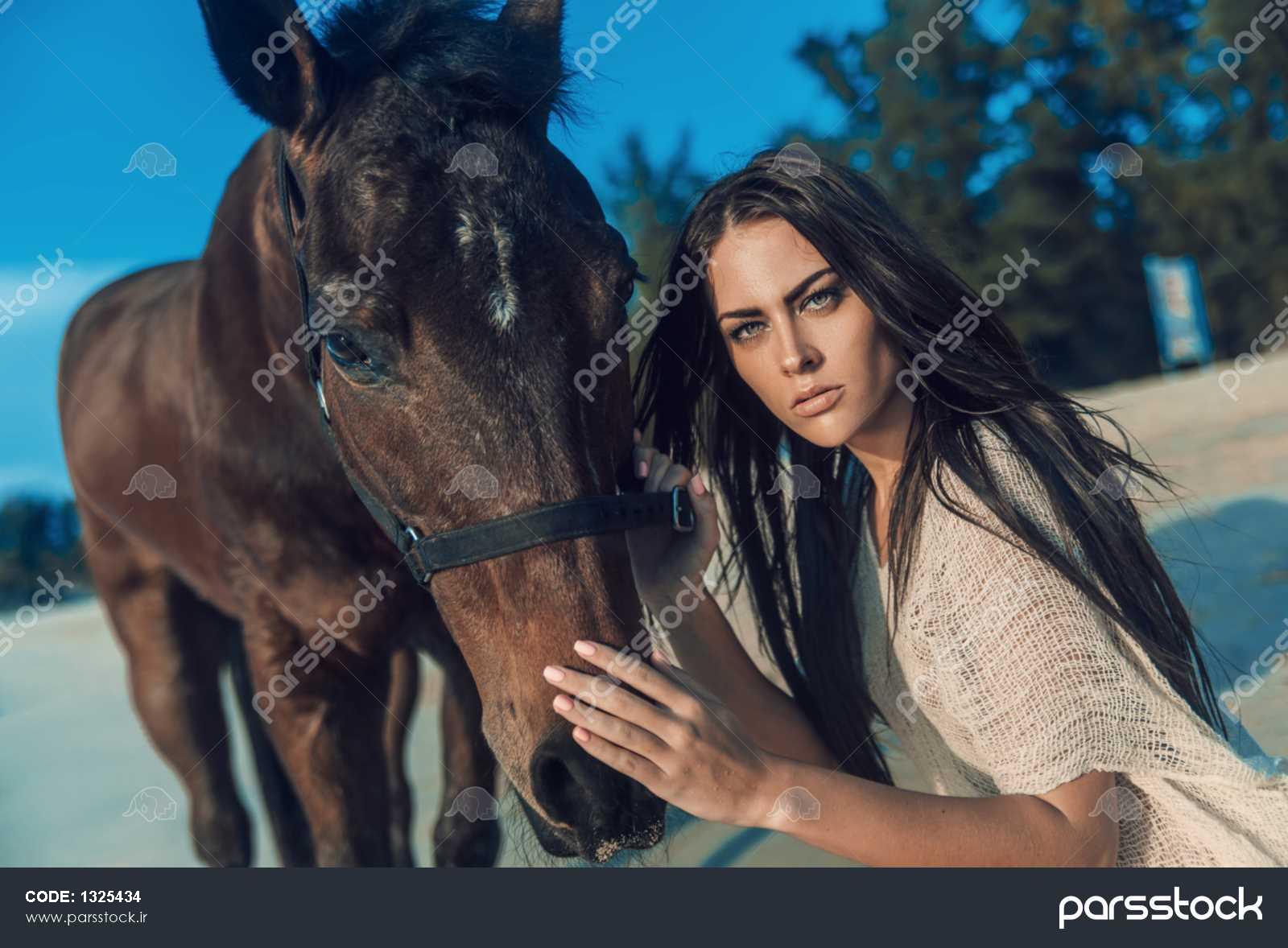 زیبایی جوان در حال تفریح با اسب در ساحل 1325434