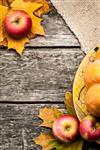 قاب پاییزی از سیب و برگ های افرا روی میز چوبی قدیمی مفهوم روز شکرگزاری