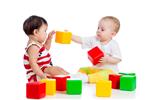 دو نوزاد یا بچه در حال بازی با اسباب بازی های رنگی