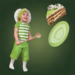 کودک سرآشپز با یک قاشق بزرگ و کیک شیرین در زمینه سبز