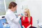 پرتره نزدیک شاد بیمار زن خندان زنی نشسته روی صندلی کلینیک مطب دندانپزشکی متخصص مراقبت های بهداشتی زن پزشک دندانپزشک که مدل دندان ها را نشان می دهد پروتز مصنوعی روش را توضیح می دهد
