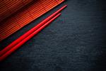 چینی های چینی قرمز ژاپنی و بامبو مات بر روی تخته سیاه پس زمینه منو