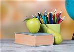 کره سیب و مداد روی میز چوبی بازگشت به مفهوم مدرسه