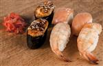 رول سوشی ژاپنی تازه خوشمزه ست با ماهی آزاد مارماهی پنیر کالیفرنیا قلیه ماهی پرنده خاویار قرمز واسابی خردل روی یک تخته چوبی پست عالی برای روزنامه ها مجلات