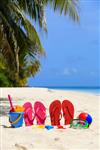 دمپایی رنگی اسباب بازی و ماسک غواصی در ساحل مفهوم تعطیلات