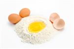 یک تخم مرغ در مقداری آرد آماده برای پخت با تخم مرغ و پوسته تخم مرغ در طرفین