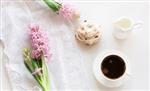 صبحانه عاشقانه صبحگاهی فنجان قهوه کوزه شیر و کیک با دکور سنبل صورتی مفهوم بهار نمای بالا