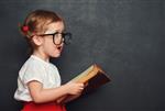 دختر مدرسه ای شاد خنده دار با کتاب از تخته سیاه