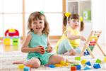 کودکان دختر نوپا در خانه مهدکودک یا مهدکودک اسباب بازی های منطقی برای یادگیری اشکال حساب و رنگ ها بازی می کنند