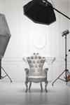 صندلی سفید عتیقه در آتلیه عکاسی با تجهیزات نورپردازی مدرن