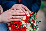 دستان یک زوج تازه ازدواج کرده روی دسته گل عروسی