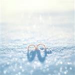 مفهوم عروسی دو حلقه طلا در برف در روز زمستان