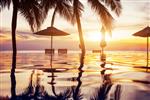 استخر شنا ساحل در غروب آفتاب با بازتاب درختان نخل چشم انداز استوایی هتل جزیره ای عجیب و غریب