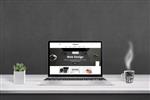ارائه آژانس طراحی وب با طراحی سایت صاف و پاسخگو بر روی صفحه نمایش لپ تاپ فنجان قهوه و بشقاب کنار دیوار سیاه در پس زمینه