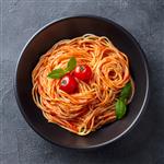 ماکارونی اسپاگتی با سس گوجه فرنگی در کاسه سیاه زمینه سنگ خاکستری نمای بالا نزدیک