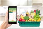 فروشگاه خرید مواد غذایی آنلاین در صفحه گوشی های هوشمند با مواد غذایی در خانه در پس زمینه