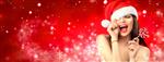 زن کریسمس دختر مدل زیبایی در کلاه بابا نوئل با لب های قرمز و آب نبات شیرین ابریشمی در دست خود شادی ابراز تعجب پرتره نزدیک روی پس زمینه گسترده برف زمستانی قرمز با copyspace