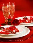 تصویر تنظیم سفره لوکس شام عاشقانه ظروف مخصوص جشن عروسی با ظروف نقره ای و عینک مخصوص شامپاین تزئین شده با گل و شمع های گل رز قرمز روز مفهوم عشق