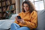 دختر نوجوان اسپانیایی هزاره مبارک در حال چک کردن شبکه های اجتماعی که گوشی هوشمند در خانه دارد زن جوان لاتین خندان با استفاده از برنامه تلفن همراه در حال بازی کردن خرید آنلاین سفارش تحویل روی مبل استراحت کنید