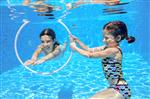 بچه‌های فعال شاد در استخر شنا می‌کنند و زیر آب بازی می‌کنند دختران در حال غواصی و تفریح کودکان در تعطیلات تابستانی مفهوم ورزشی